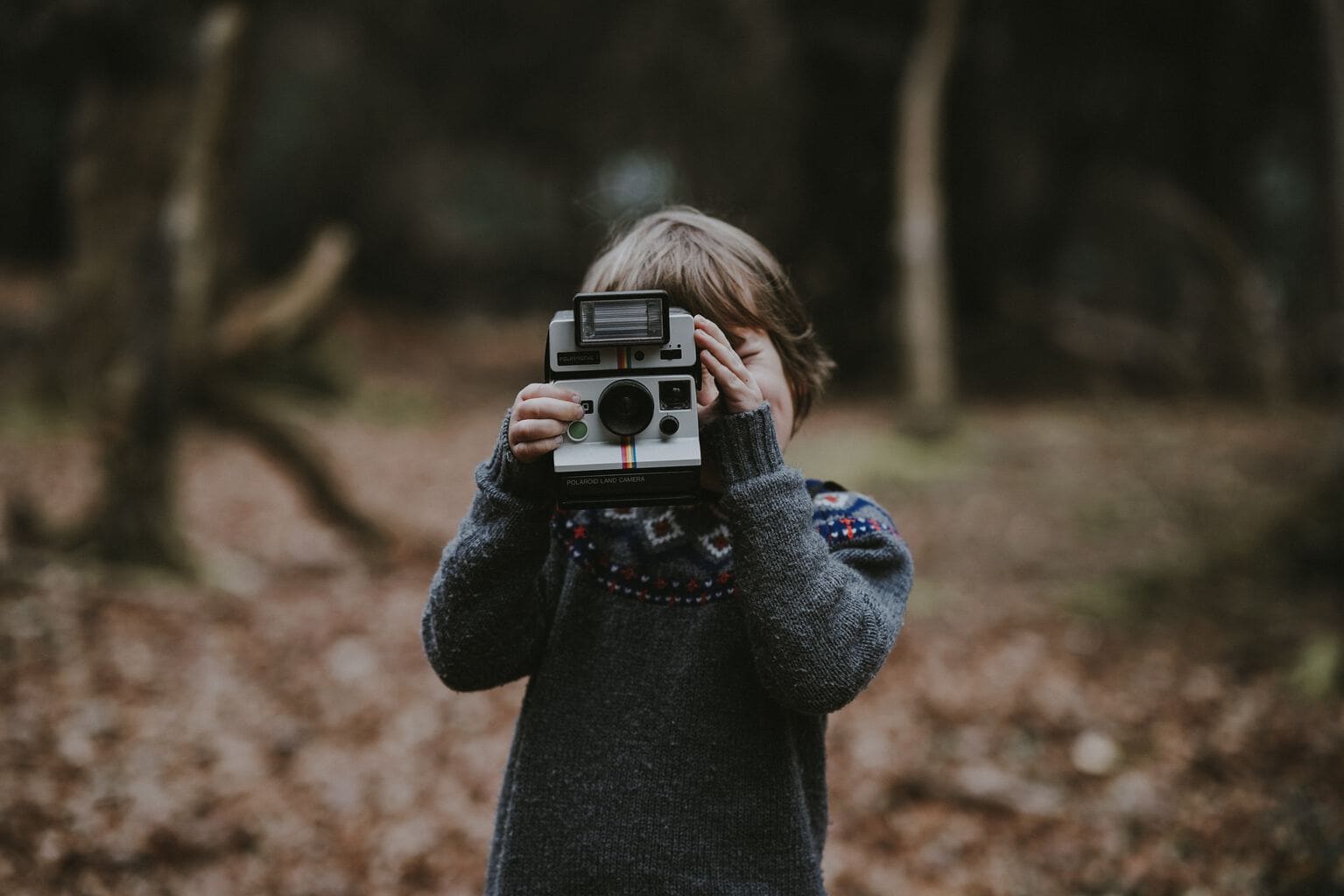 Fotografía joven realizando una fotografía con una cámara instantánea